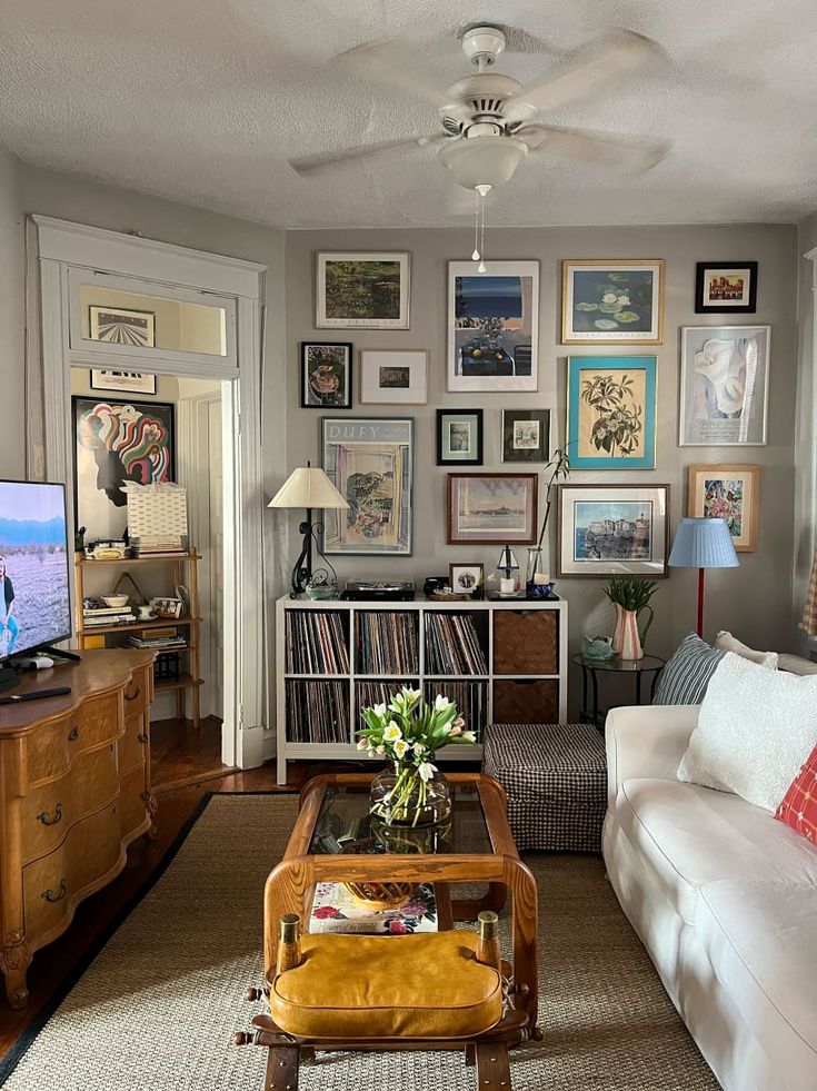 a living room filled with lots of furniture and pictures on the wall above it's coffee table