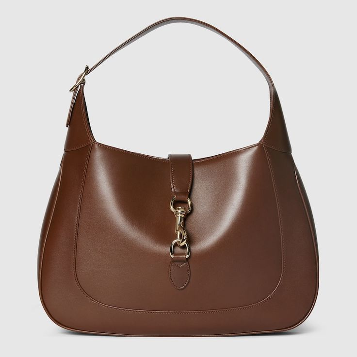 "Find GUCCI Jackie Shoulder Bag on Editorialist. The Gucci Jackie shoulder bag features premium fine leather. The bag showcases the House's iconic shoulder bag silhouette. It has a light gold-toned hook closure, leather trim, and an additional green and red Web strap. The bag has a leather lining, one zip pocket with a Gucci Crest zip puller, a 7.5\" handle drop, a detachable Web shoulder strap with a 20.5\" drop, and a hook closure. It weighs 1.3lbs and is approximately 13.8\"W x 12.6\"H x 2.2\ Popular Designer Bags, Tv Closet, Gucci Jackie 1961, Merchandise Ideas, Backpack Handbag, Chanel Flap Bag, Cobble Hill, Zip Puller, Gucci Gucci