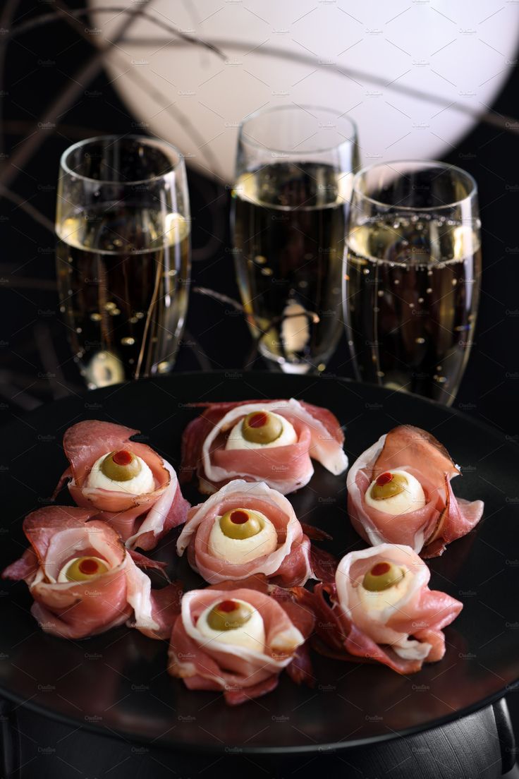 small appetizers are arranged on a black plate