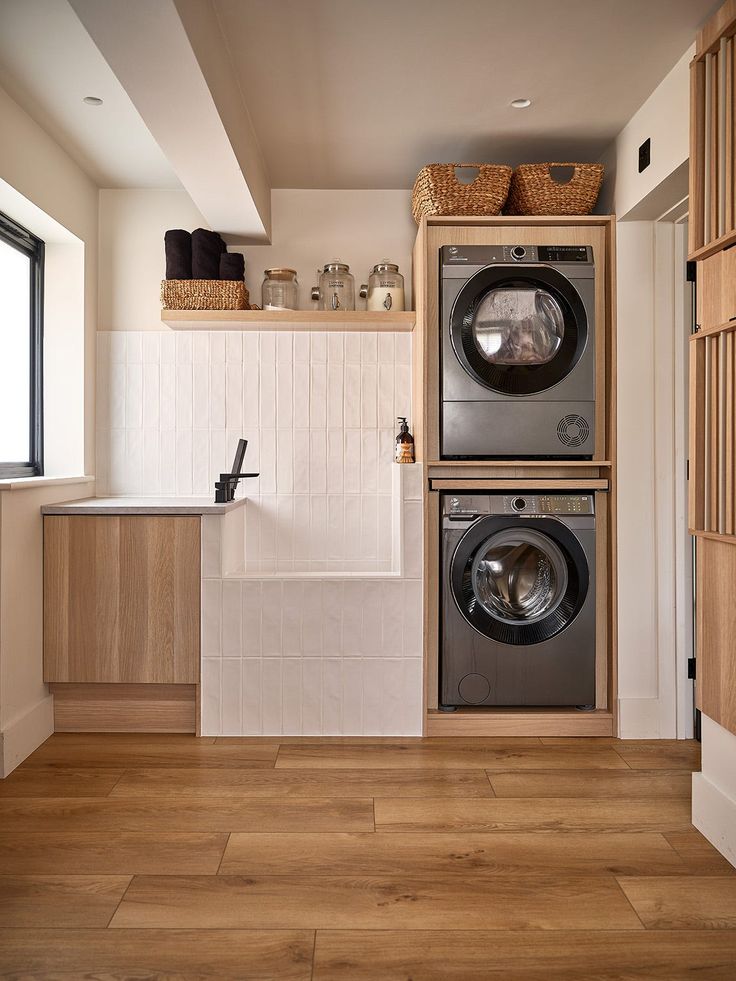 a washer and dryer in a small room with wood flooring on the walls