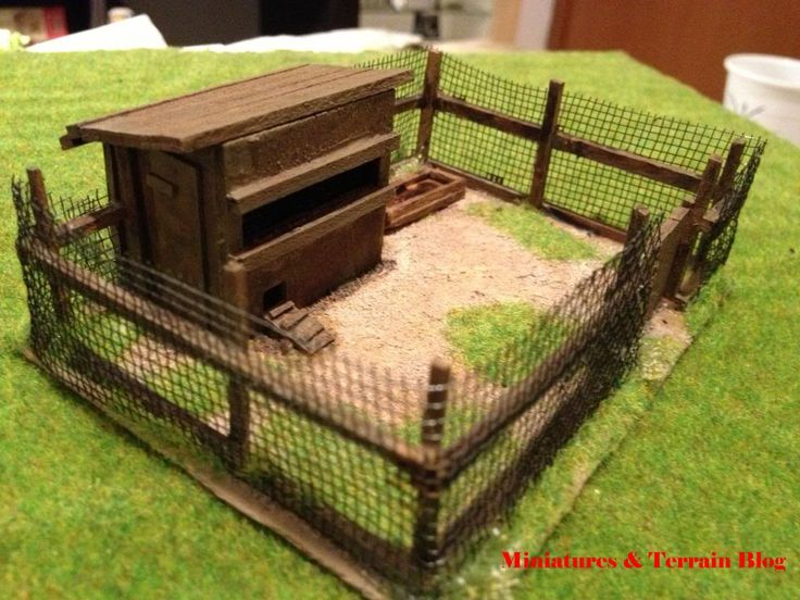 a toy model of a chicken coop in the grass