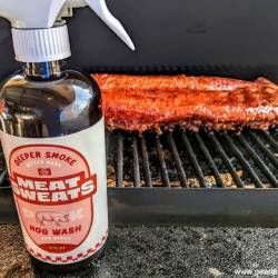 a bottle of meat is next to an open grill