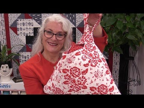 a woman holding up a red and white bag