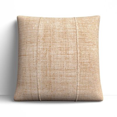 a beige pillow sitting on top of a white wall