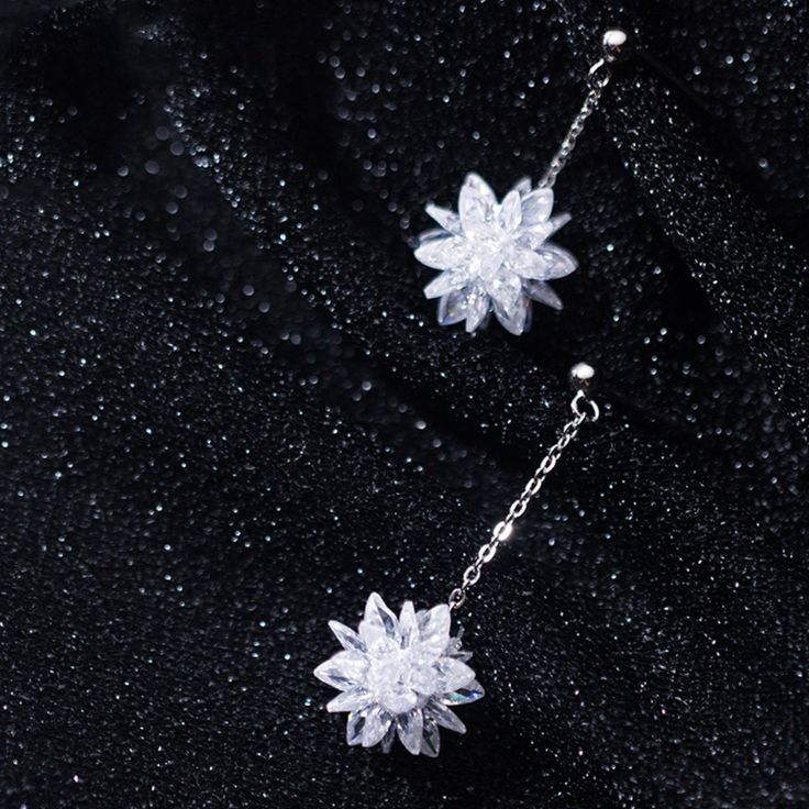 This pair of snow flower dangle drop earrings features a beautiful snowflake / lotus flower in white crystal with dangle chain made of solid 925 sterling silver with platinum platting. Add this pair of white flower dangle drop earrings to your everyday fine jewelry collection or as gift for your love one this Christmas holiday season. Jewelry Care: See more information about how to care for your jewelry here. Shipping Policy: Orders will be shipped within 1-3 business days. Economy shipping will Winter Inspired Jewelry, Silver Crystal Flower Earrings For Gift, White Sterling Silver Flower Earrings For Party, Snow Earrings, Christmas Gift Earrings, Snowflake Jewelry, Flower Christmas, Snow Flower, Snowflake Earrings