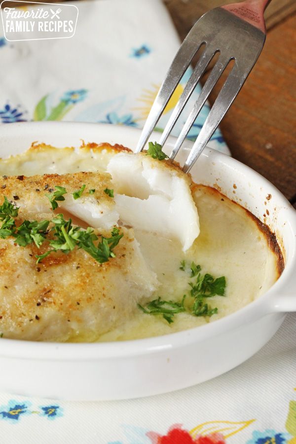 a white plate topped with fish covered in gravy