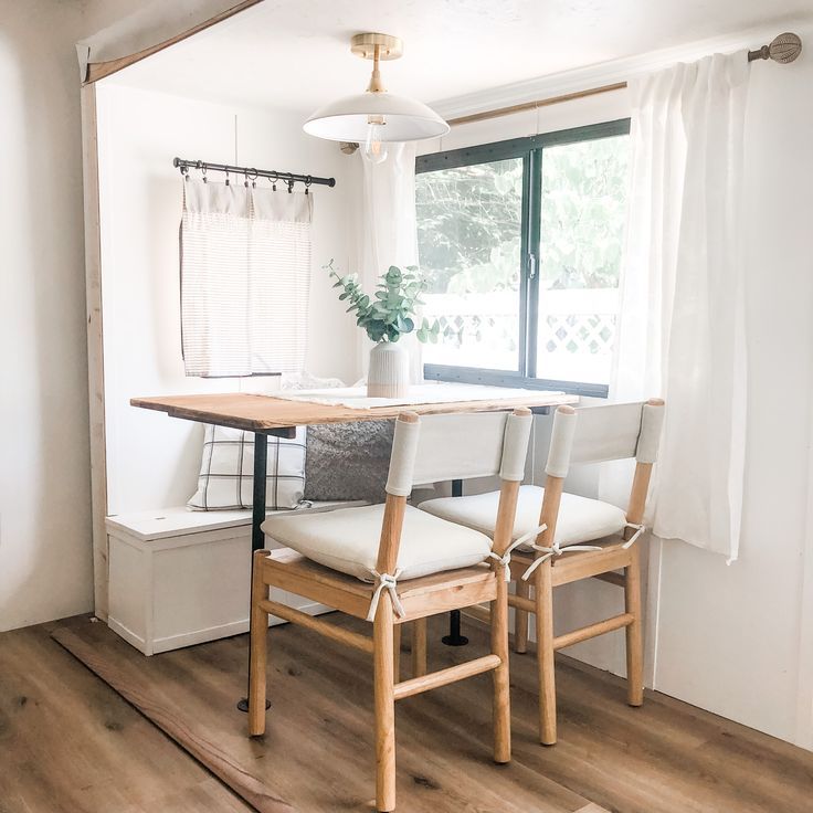 a dining room table with four chairs and a potted plant on the top shelf