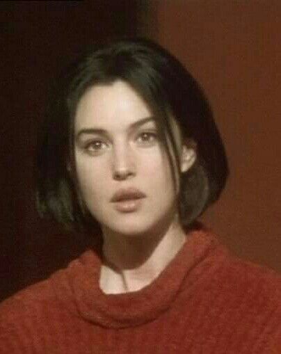 a woman with dark hair wearing a red sweater