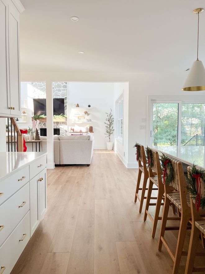 an open kitchen and dining room with white cabinets, wood flooring and hardwood floors