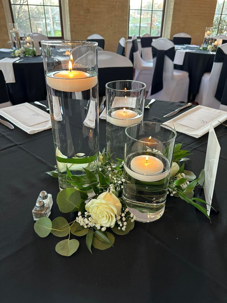 the centerpieces are set up with candles and greenery