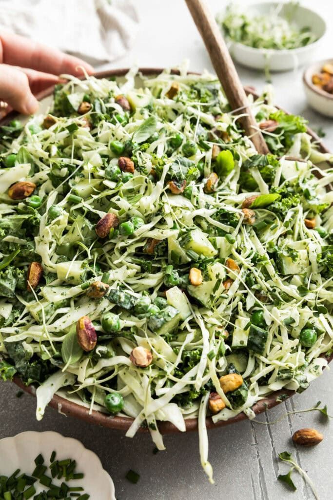 someone is sprouting broccoli in a bowl with other dishes around it