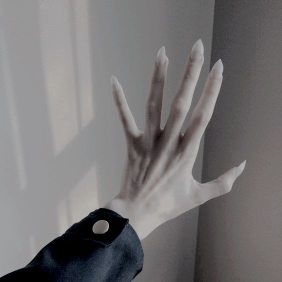 a person's hand reaching out to touch the wall with their left arm and fingers