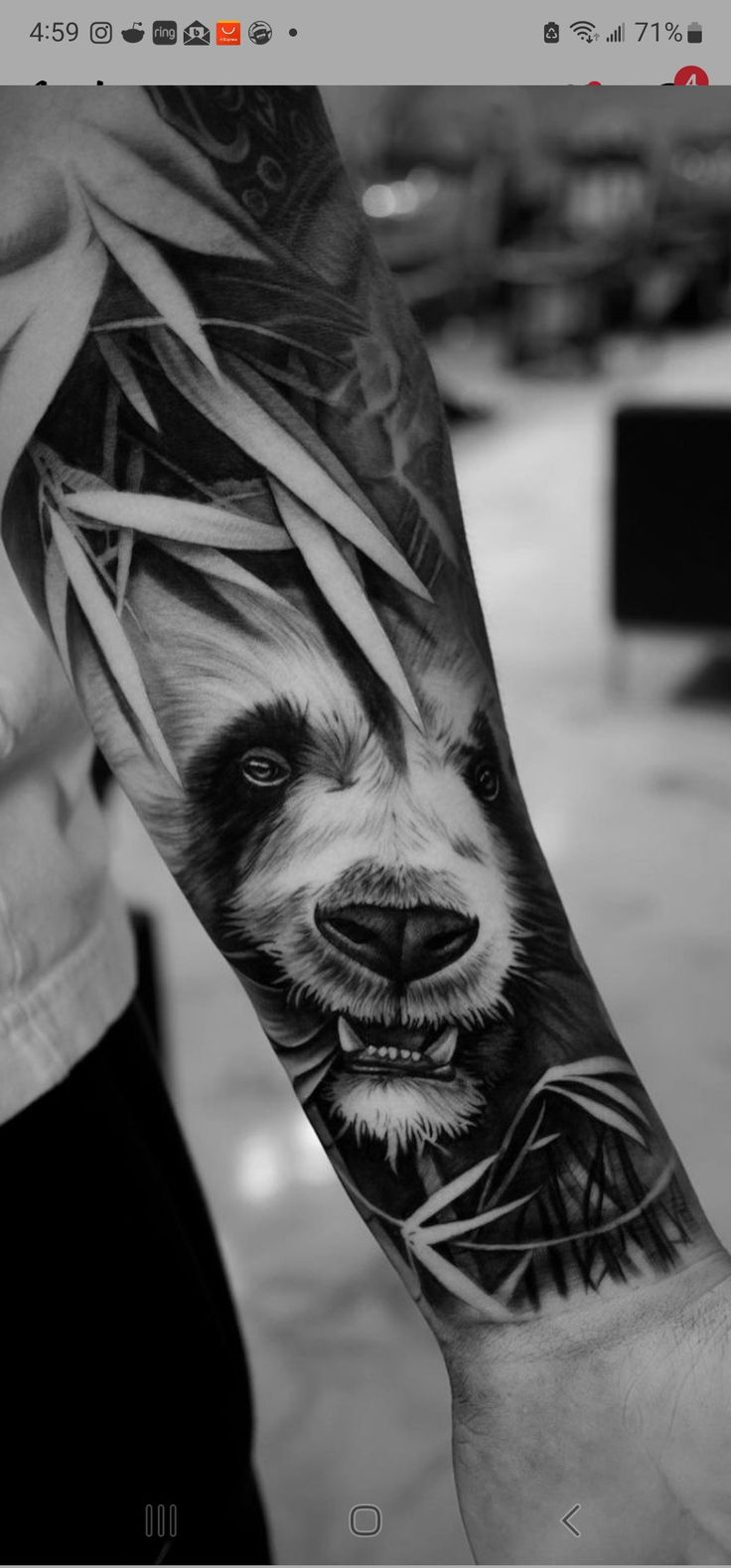 a man with a tattoo on his arm that has a panda face and bamboo leaves