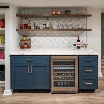 a wine cooler in the middle of a kitchen with open shelving and shelves above it