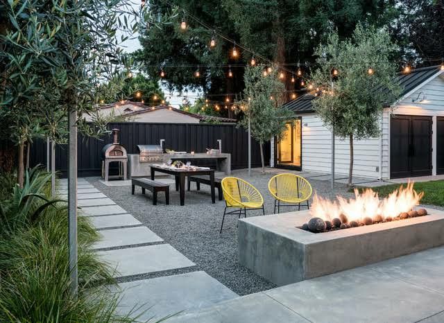 an outdoor fire pit surrounded by chairs and tables