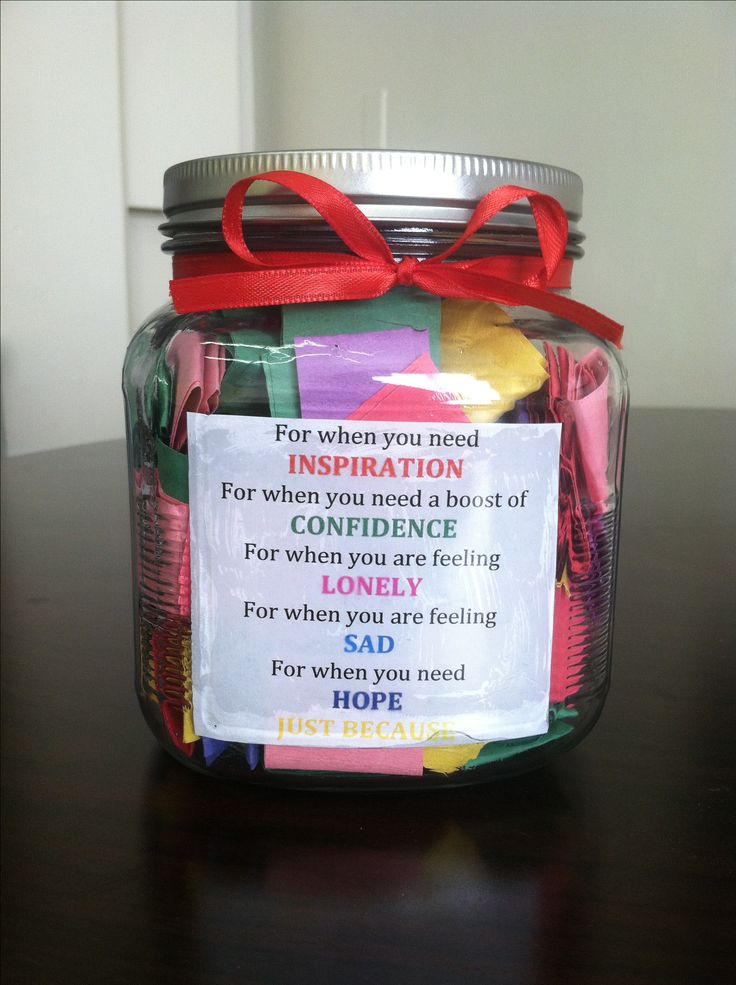 a jar filled with lots of different colored pieces of paper on top of a table