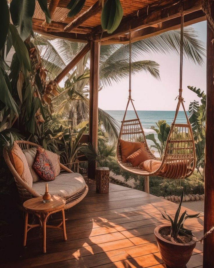 a porch with hammock chairs and palm trees on the deck overlooking the ocean