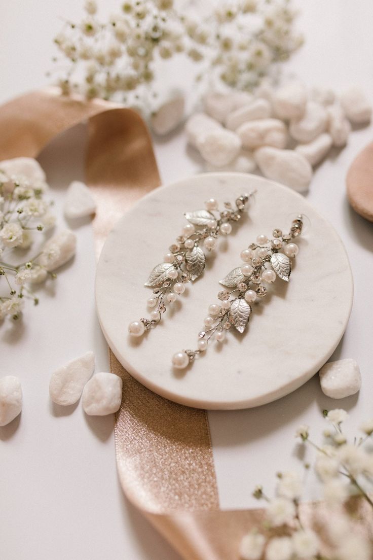 two pairs of earrings sitting on top of a table