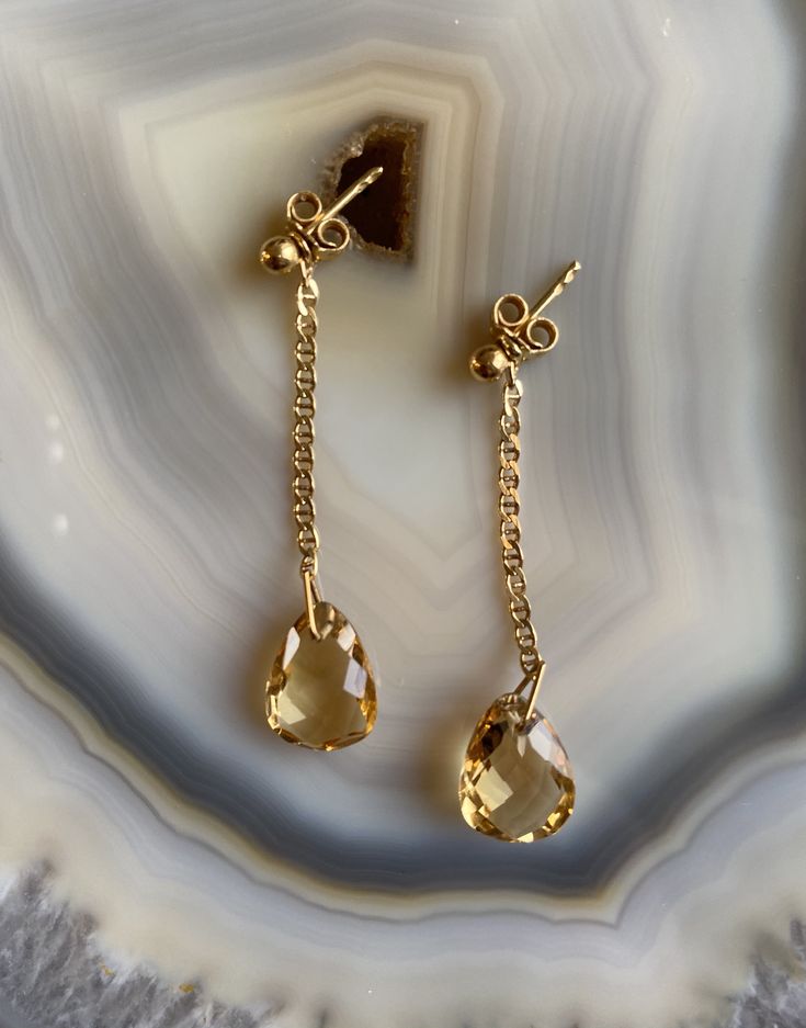 Delicate, feminine and so gorgeous! This is an 18k Gold Filled Earrings featuring a beautiful polished Citrine gemstone. You can see how clear is this stone’s cut. Amazing! Citrine is a great gem to wear to increase motivation! You will love how it will match a lot of your outfits! Product Details: . Size: 2” . Material: 18k Gold Filled Teardrop Gemstone Earrings In Yellow Gold, Elegant Teardrop Gemstones With Matching Earrings, Elegant Gold Dangle Gemstones, Elegant Yellow Gold Topaz Gemstones, Elegant Citrine Gemstones With Gemstone Accents, Faceted Teardrop Citrine Jewelry, Teardrop Faceted Citrine Jewelry, Topaz Drop Jewelry For Gifts, Gold Teardrop Gemstones