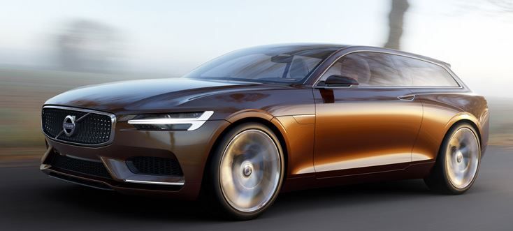 the new volvo concept car is driving down the road with blurry trees in the background