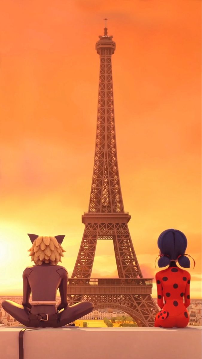 two people sitting in front of the eiffel tower, looking at the sunset