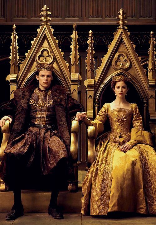 a man and woman dressed in period costumes sitting on thrones