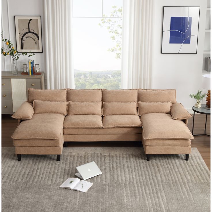 a living room with a sectional couch and two pillows on the floor next to it