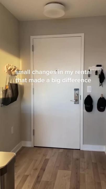 an empty room with a white door and some hats hanging on the wall next to it