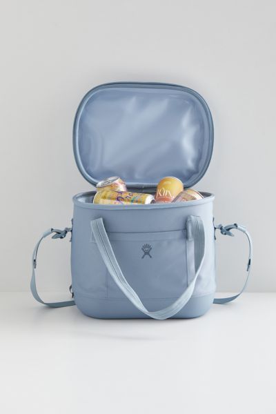 a blue cooler bag filled with food and drinks sitting on top of a white table