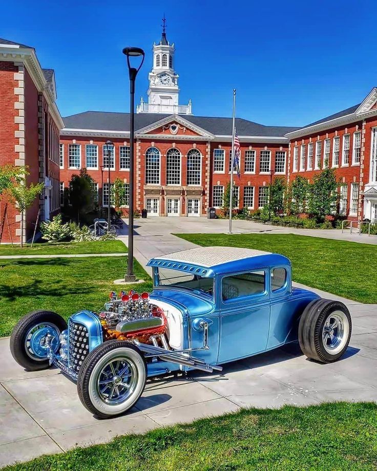 an antique car parked in front of a building