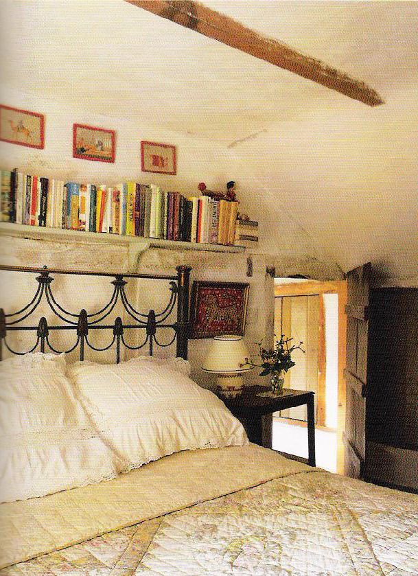 a bedroom with a bed, bookshelf and pictures on the wall above it