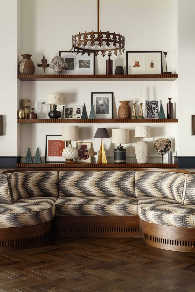 a living room filled with lots of furniture and pictures on the wall above it's shelves