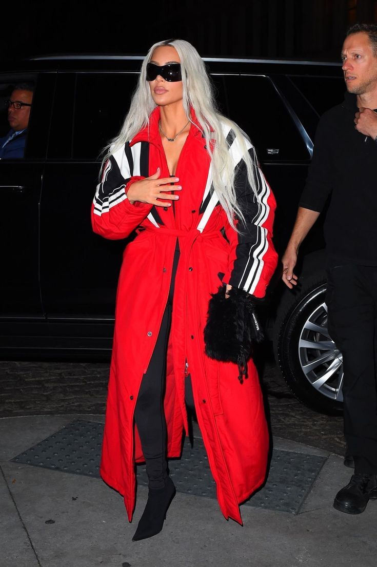 lady with long white hair wearing red coat and black leggings