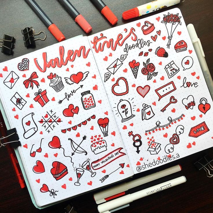 an open notebook with various stickers and markers on it, including the word valentine's day