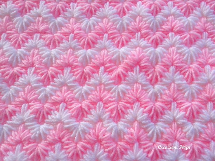 the pink and white crocheted blanket is made up of many different colored yarns