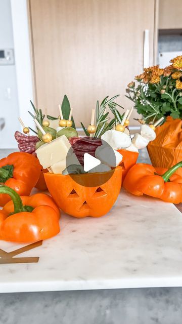 an arrangement of pumpkins and flowers on a kitchen counter