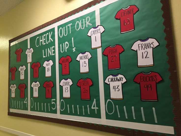 a bulletin board with baseball uniforms on it in the hallway at an elementary school for boys