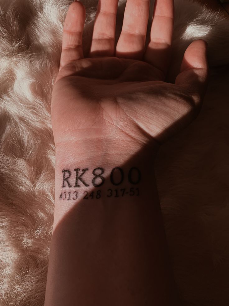 a person's arm with a tattoo on it that reads rk & 00