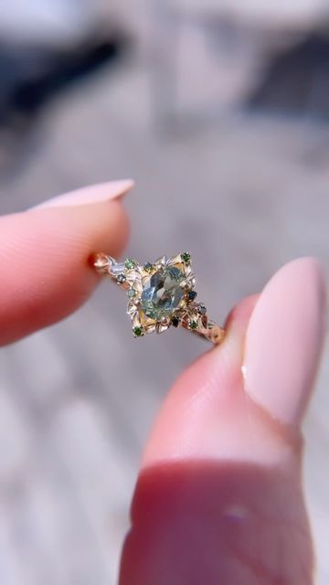 a person is holding an engagement ring in their hand, with the diamond on it's side