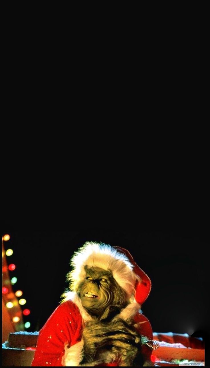 a man dressed as santa claus sitting in front of a christmas tree