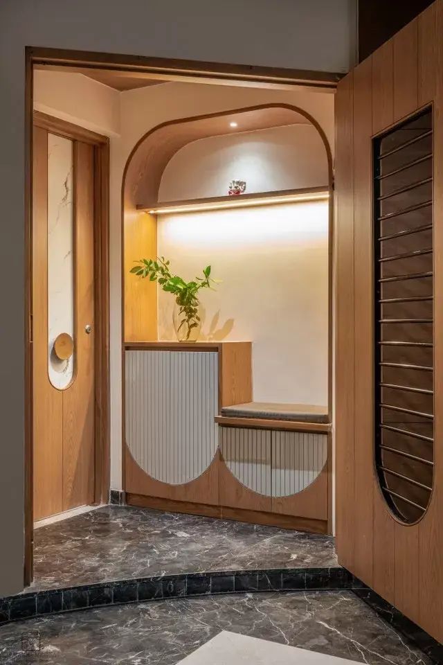 an entry way with a plant in the center and wooden doors on both sides that lead to another room