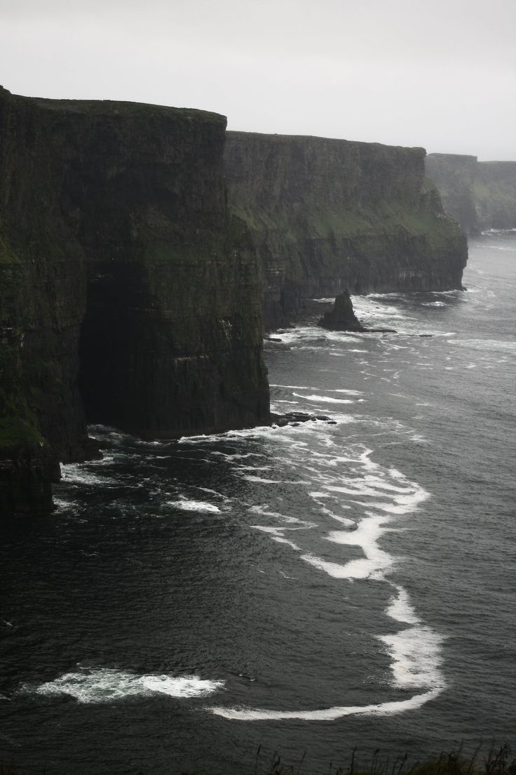 an ocean cliff with waves coming in from the cliffs