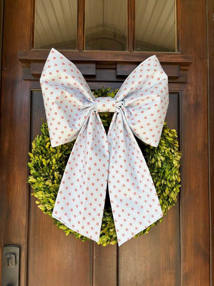 a wreath with a bow hanging on the front door