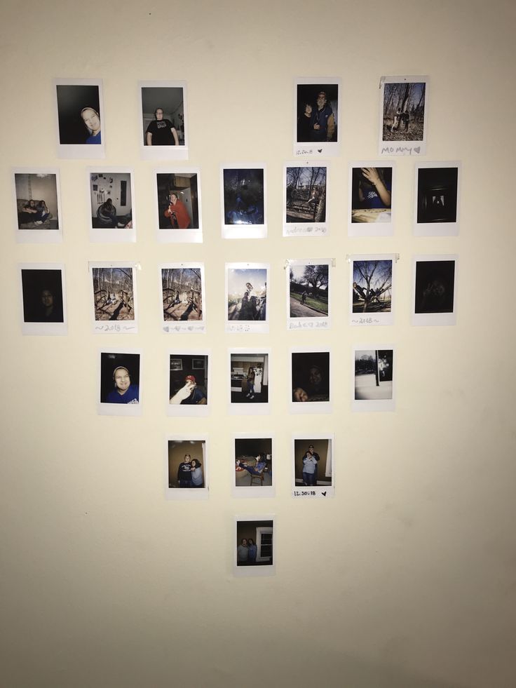 a white wall with many black and white photos hanging on it's side,