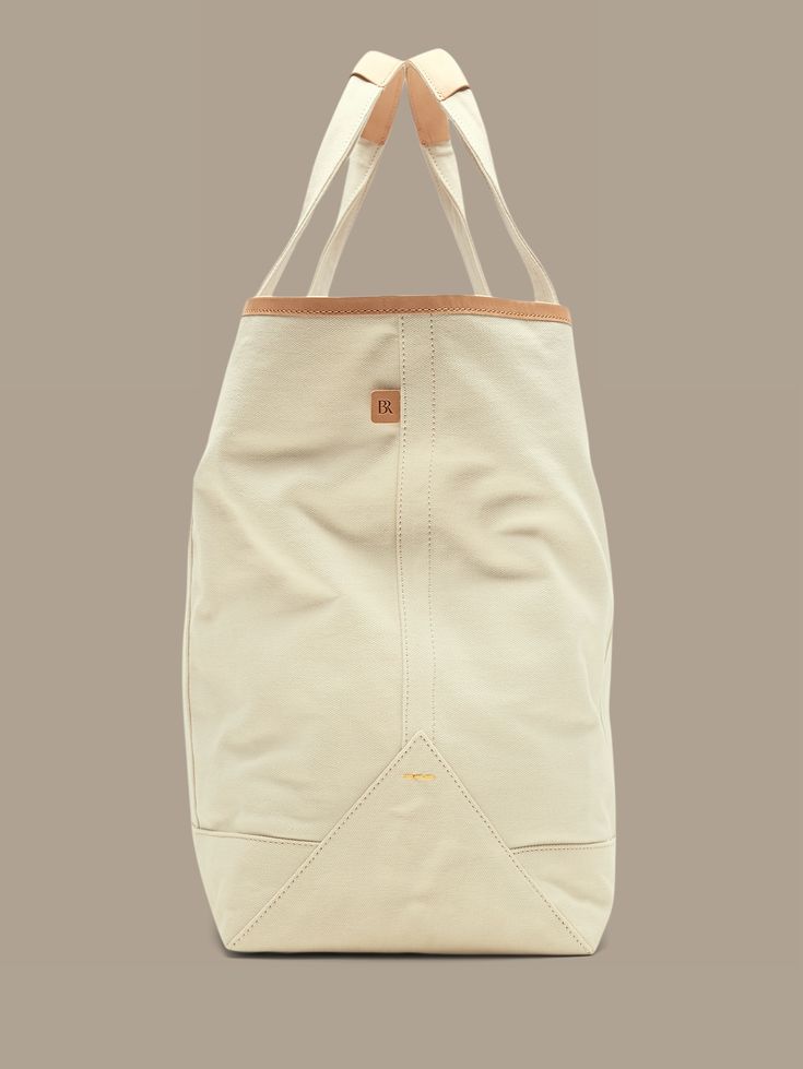 Ready for adventure, this sturdy tote bag is crafted from our sturdiest cotton canvas, with luxurious leather vachetta trim details so it will age gracefully with every outing.  Leather trim handles.  External slip pocket.  Magnetic tab closure.  Int Cotton Tote Weekender Bag With Pockets, Rectangular Cotton Weekender Bag With Pockets, Beige Tote Weekender Bag With Handles, Everyday Duck Canvas Bag With Pockets, Everyday Canvas Bag With Duck Canvas Lining, Casual Duck Canvas Bags With Pockets, Daily Use Shoulder Bag With Duck Canvas, Duck Canvas Tote Bag With Canvas Lining, Everyday Waxed Canvas Bag With Pockets