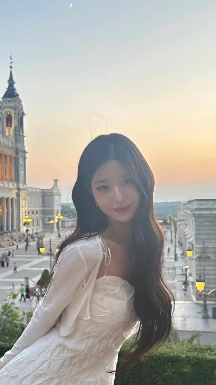 a beautiful young woman standing in front of a building