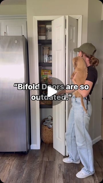 a person holding a dog in front of a refrigerator