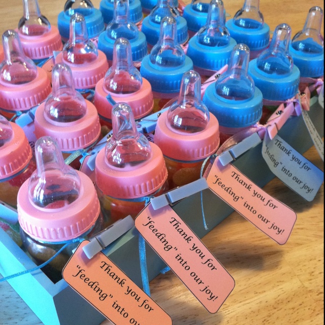 baby bottles with labels on them sitting on a table next to other bottles and tags