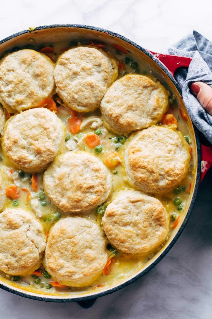 a pot filled with chicken pot pies on top of a white counter next to a red towel