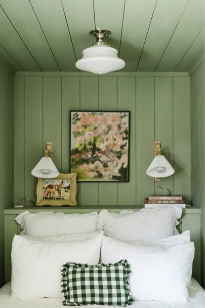 a bedroom with green walls and white bedding